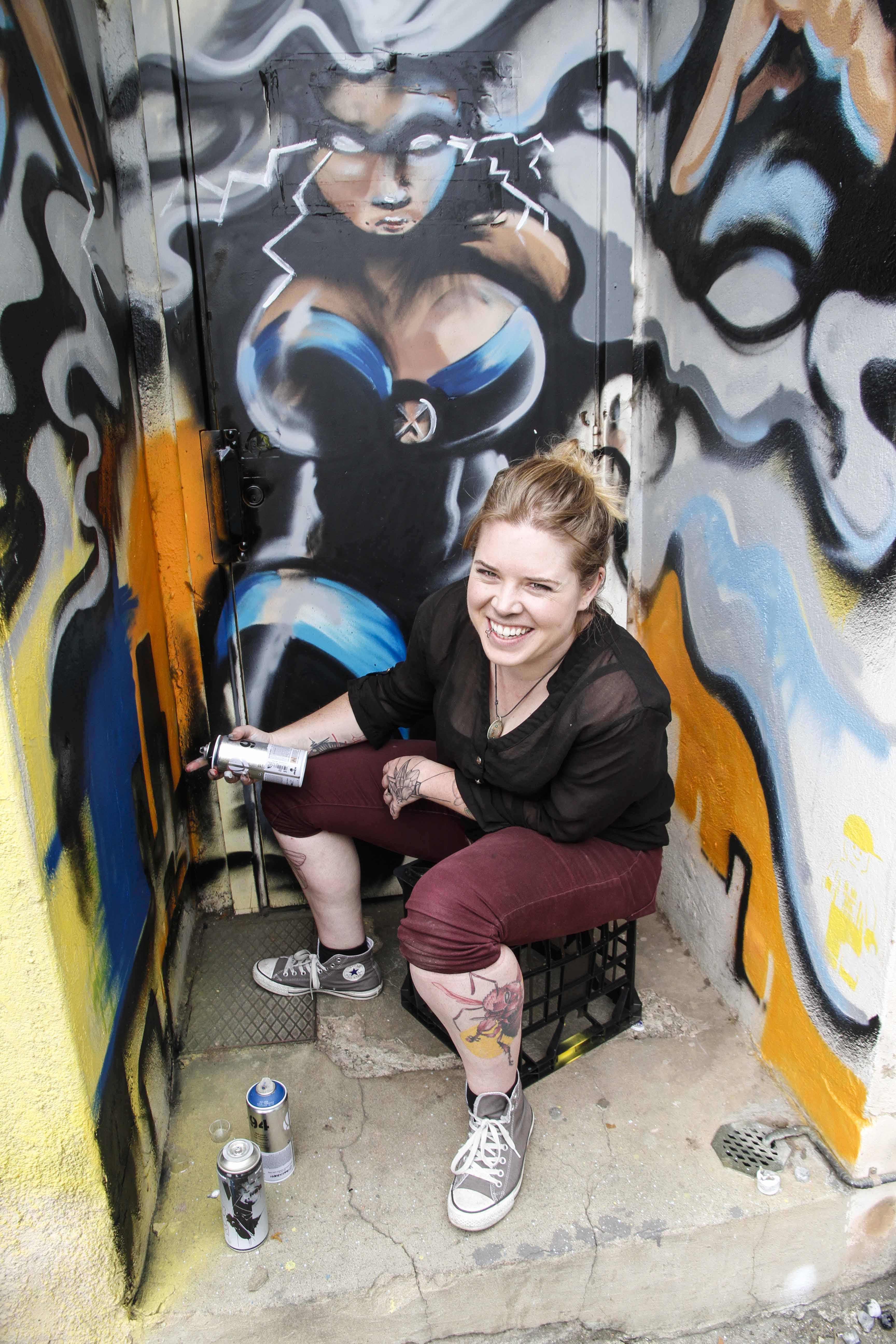 Tattoo artist Anna GK in front of her street art.