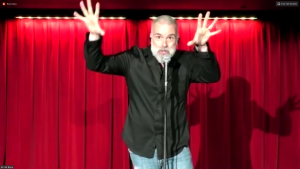 Al Del Bene, the American comic, performed in front of a red curtain. 