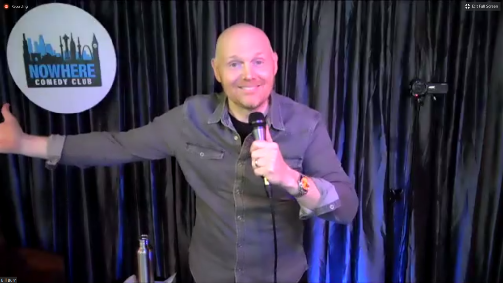 Bill Burr, the leading comic, gestures his arms wide as he begins his show. 
